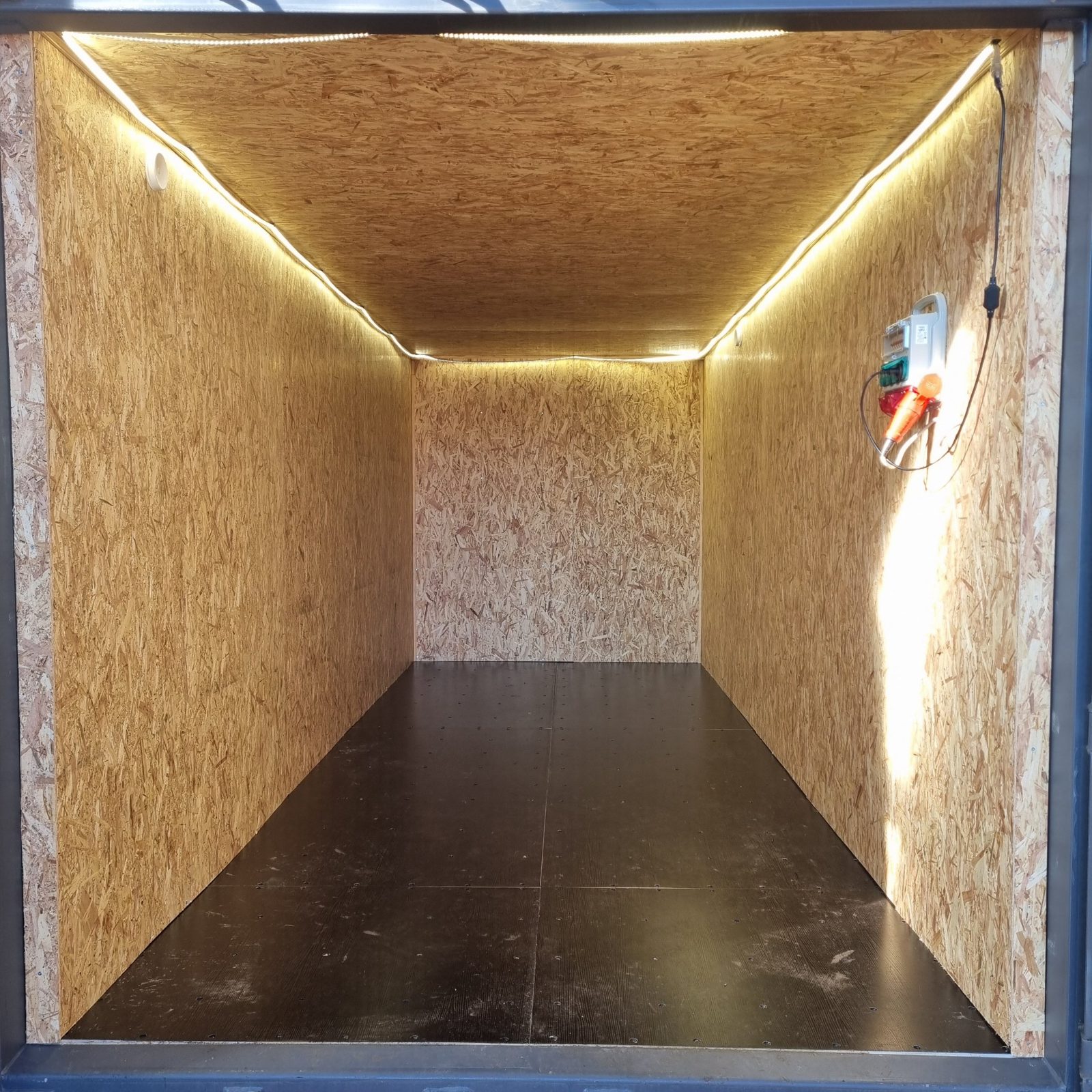 Isoleret container med LED-lys langs loftet og el-tavle